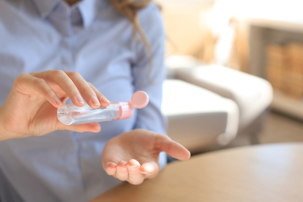 Woman using sanitizer hand gel. Hand hygiene coronavirus protection.