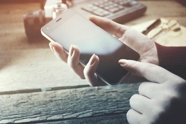 Photo woman using smart phone and coffee cup on the working table