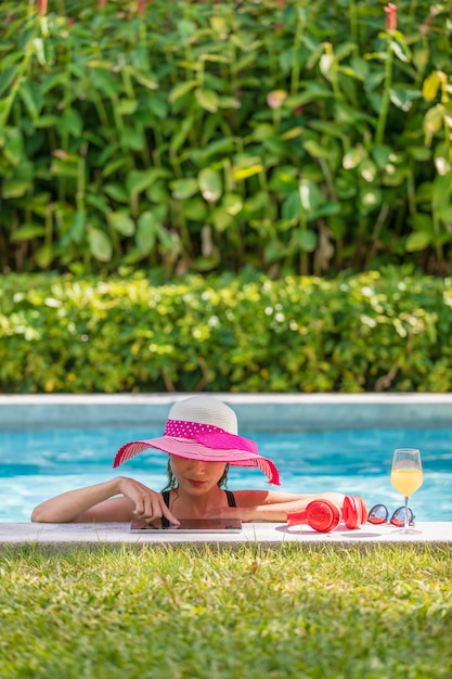 Woman using tablet computer in pool