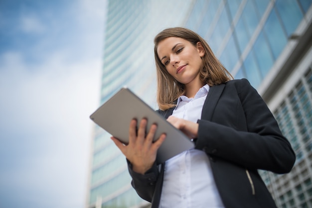 Woman using a tablet in front of her office