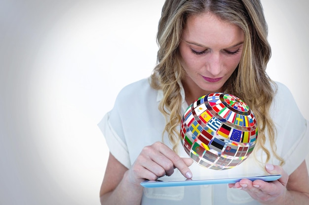 Woman using tablet pc  against sphere made of flags