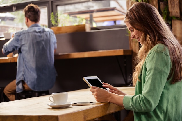 Woman using a tablet sitting and smiling