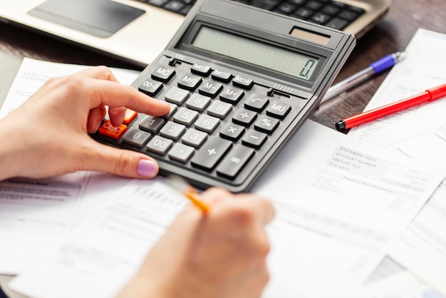 Woman using using calculator for calculate home finances or car taxes