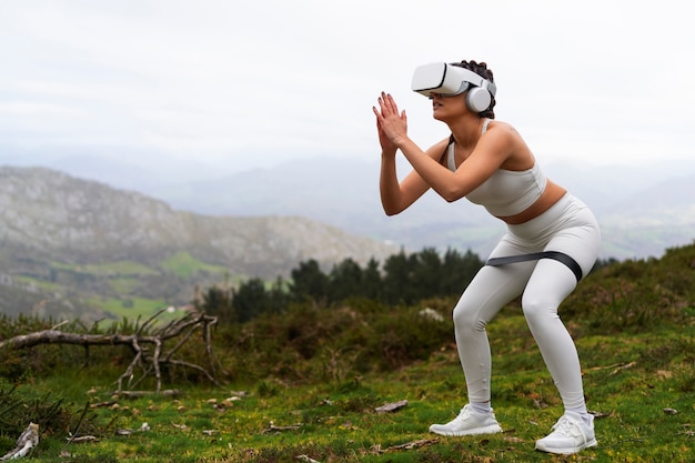 Woman using vr glasses to exercise outdoors with elastic band