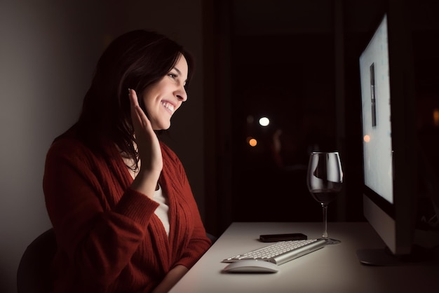 Woman in video call with a glass of wine on hand