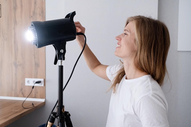 woman video maker at work working on content making using and controlling video light strobe