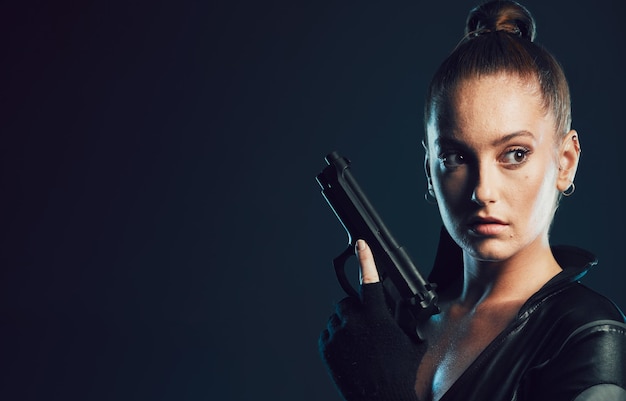 Photo woman vigilante and gun in serious war battle or agent standing ready for mission on mockup female spy holding weapon for secret operation objective or cosplay against a dark studio background