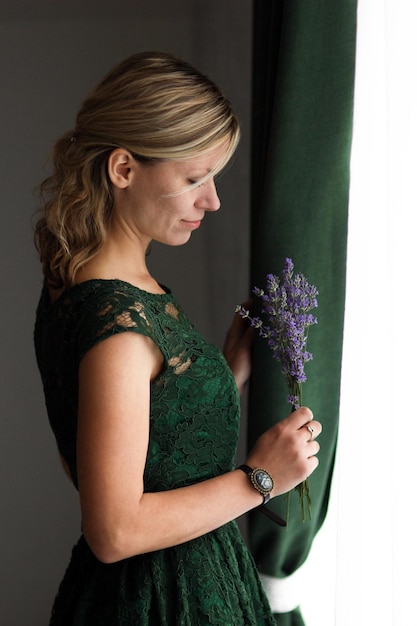 Woman in vintage dress reading by the window