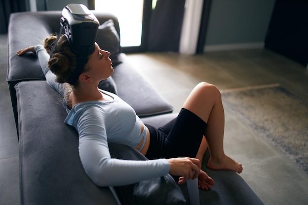 Woman in virtual reality goggles enters metaverse immersive experience via headset interface resting