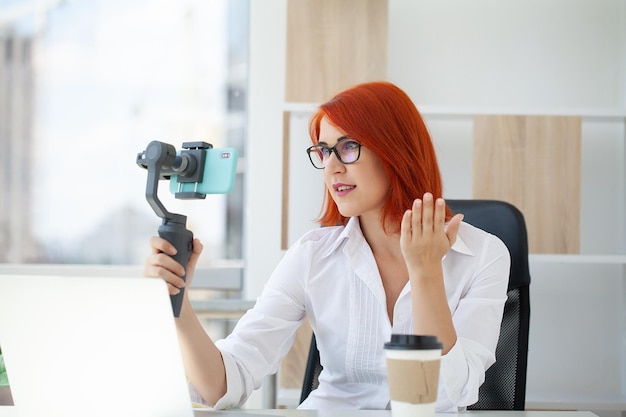 Woman vlogger recording business vlog at office desk