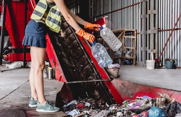 Woman-volunteer sorting trash at modern recycling plant.