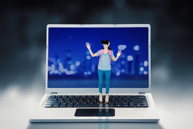 Woman in VR goggles standing on a huge laptop keyboard