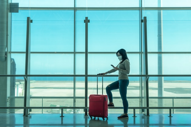 Woman waiting for airplane at airport terminal using smartphone - Fuerteventura - Spain