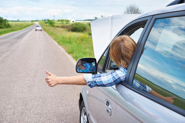 Woman waiting to help and thumbs from car