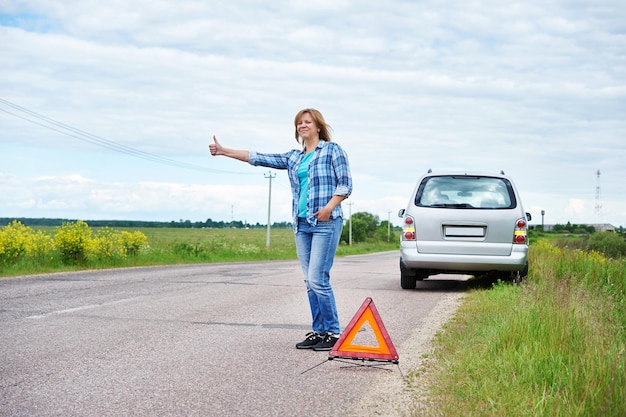 Woman waits help near broken car