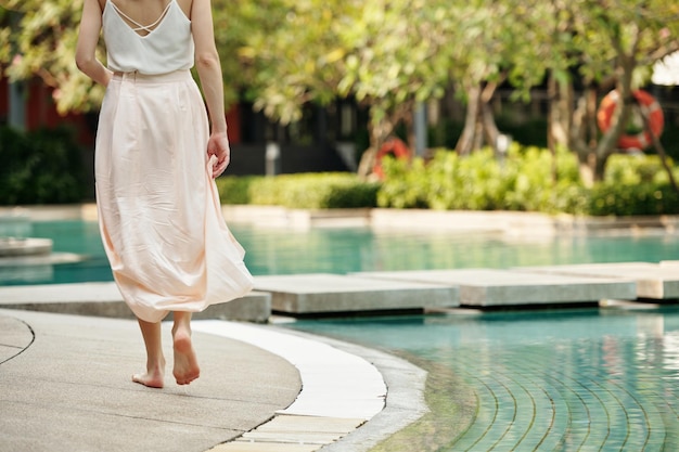 Woman walking along the outdoor pool