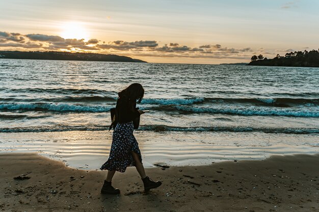 Woman walking on the beach  , sad tones, self help and minimal concept, blue tones