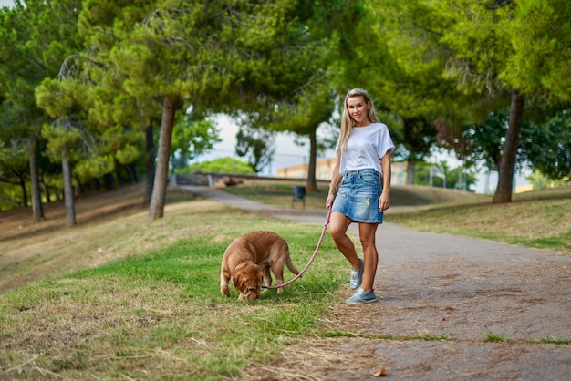 Woman walking the dog in the park.