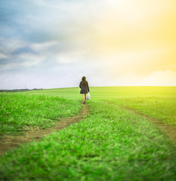 Woman walking in the field with shopping bags woman walking on a road in the field