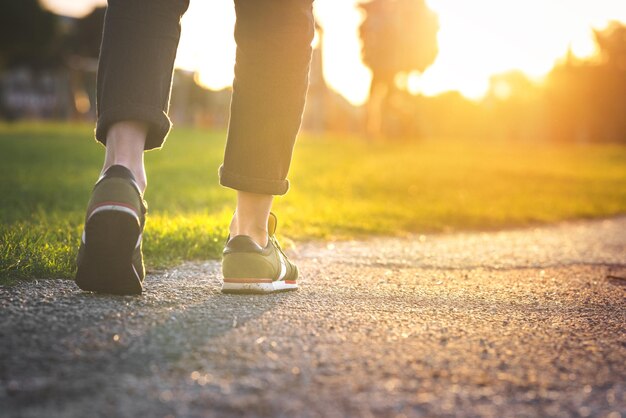 Woman walking in the park outdoors Shoes with rolled up jeans Taking a step New life concept