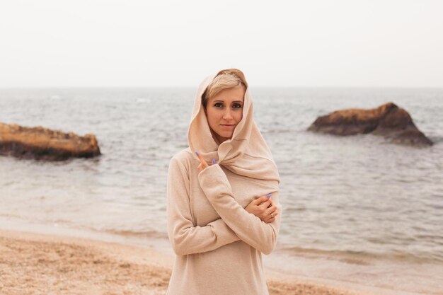 Woman walking on sandy beach near sea closeup