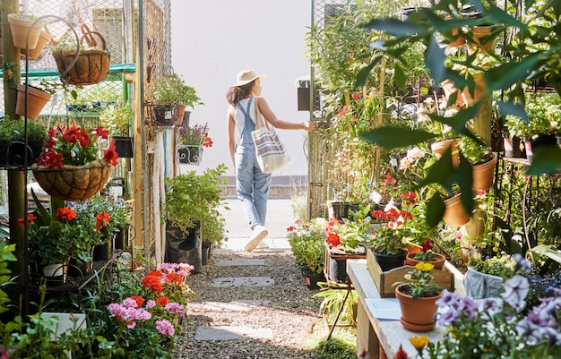 Woman walking or shopping in small business florist or green leaf plants flowers or sustainability growth Garden center nursery or greenhouse customer in spring store or Canada retail marketplace