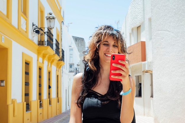 woman walking on the street looking at her smart phone