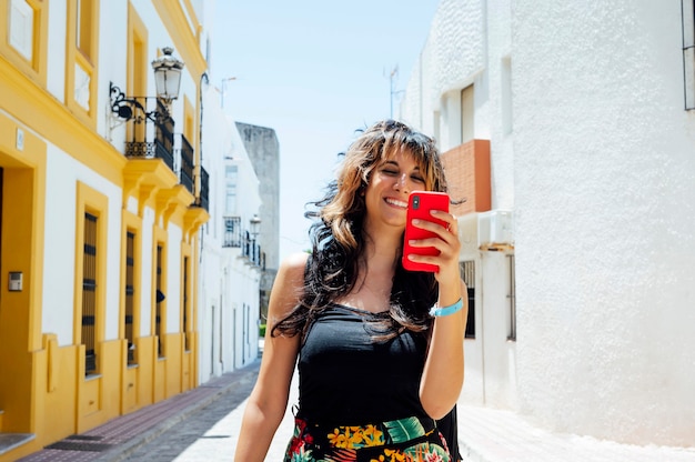 woman walking on the street looking at her smart phone