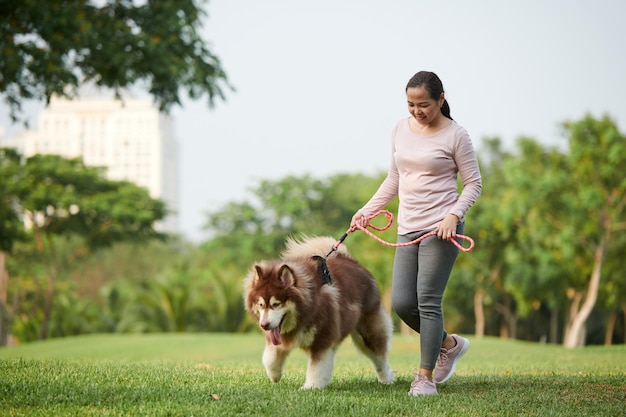 Woman Walking with Dog in Park