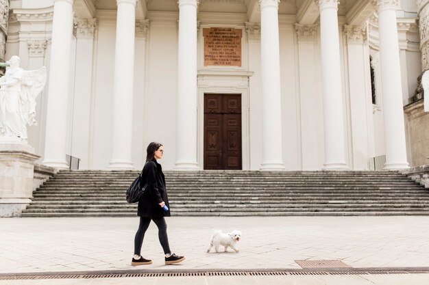 Photo woman walking with a dog on the street