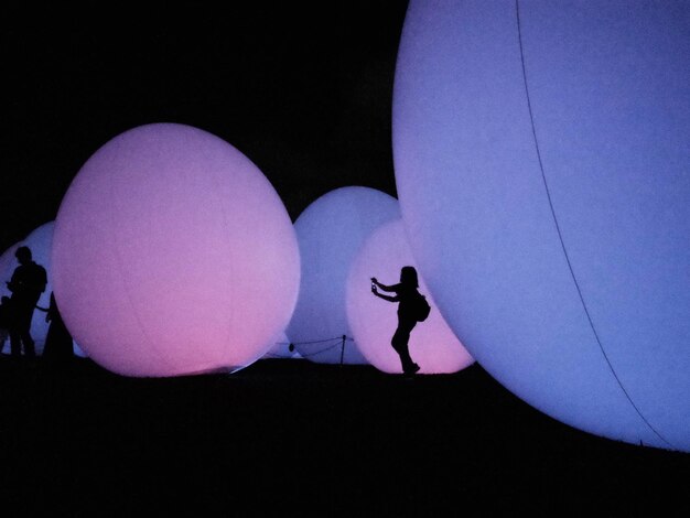 a woman walks past a light display with a silhouette of a woman