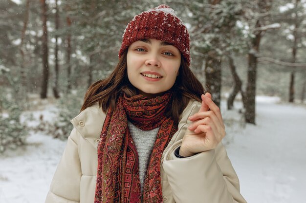 Woman in warm outerwear showing love gesture with fingers