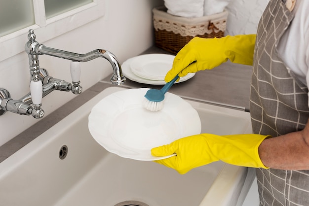 Woman washing the dishes with gloves