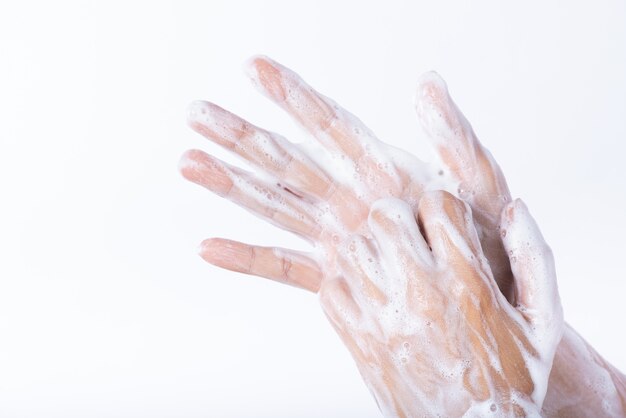 Woman washing hands with soap on white background. Healthcare concept.