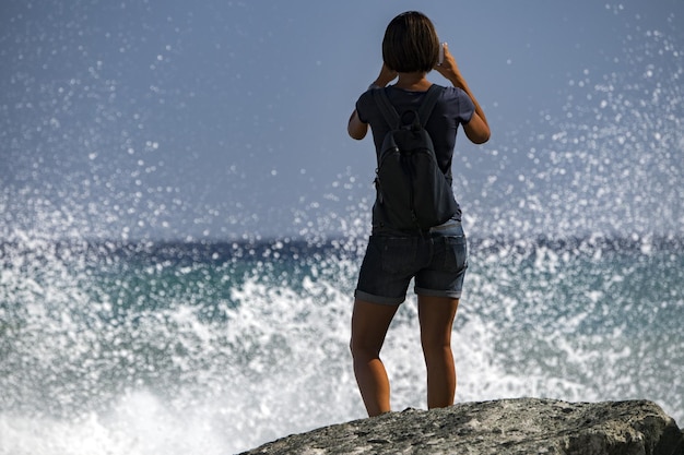 Woman watching Sea Storm tempest on the coast