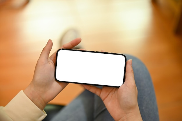 A woman watching videos or online viral clips on her smartphone in her living room