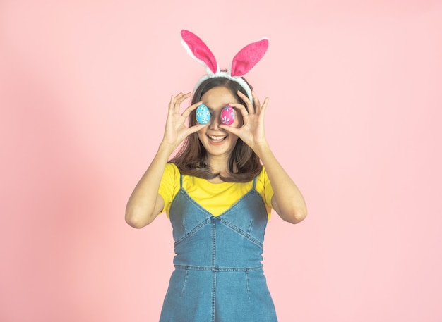 Photo woman wear bunny ear and hold easter egg cover eye