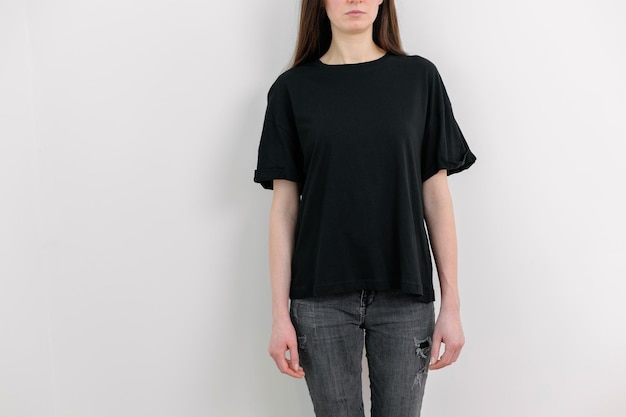 Woman wearing black blank t-shirt with space for your logo, mock up or design indoors