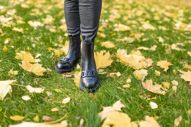 A woman wearing black boots with a tag on the bottom.