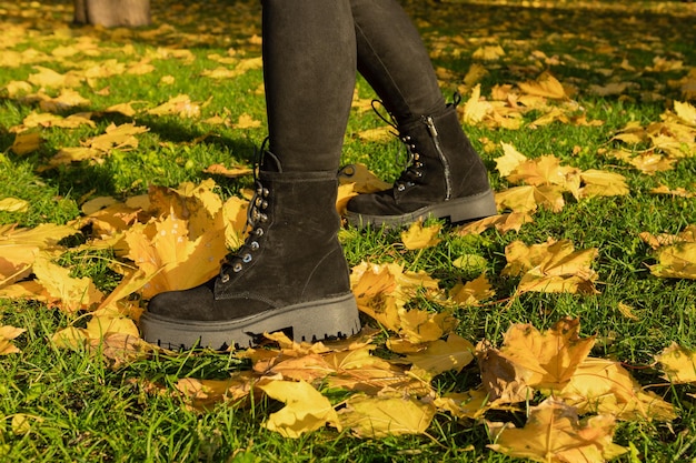 A woman wearing black boots with the word black on the bottom.