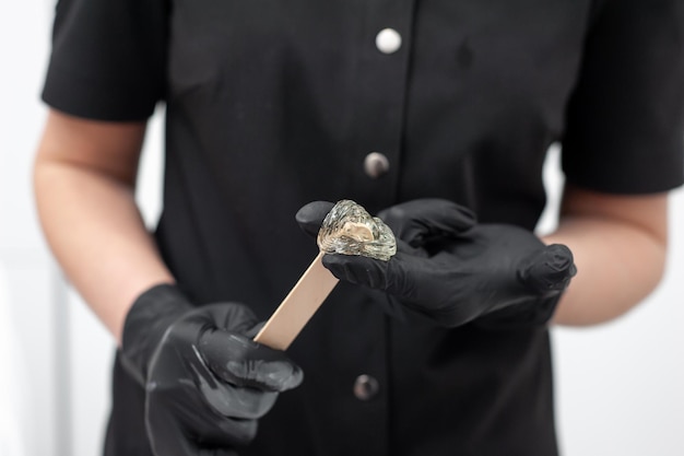 A woman wearing black gloves holds a piece of diamond.