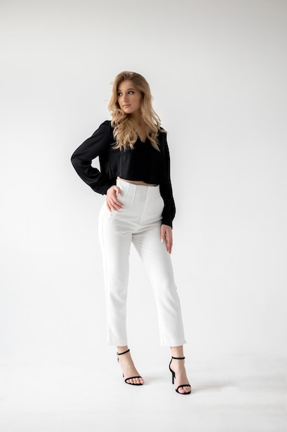 Woman wearing a black top and white pants