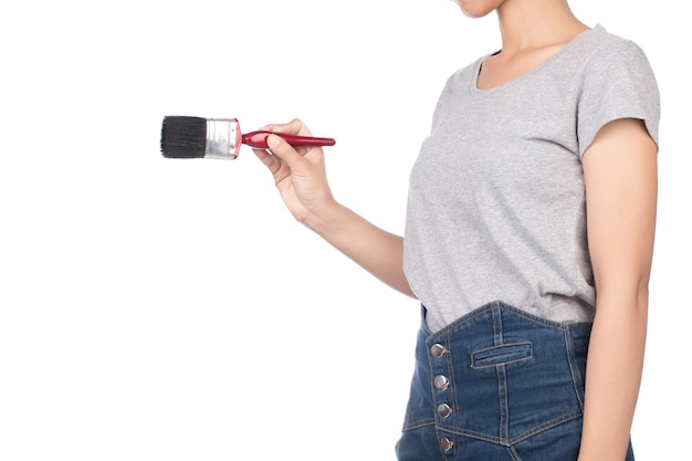 woman wearing blank gray t-shirt, jeans holding paintbrush isolated on white background