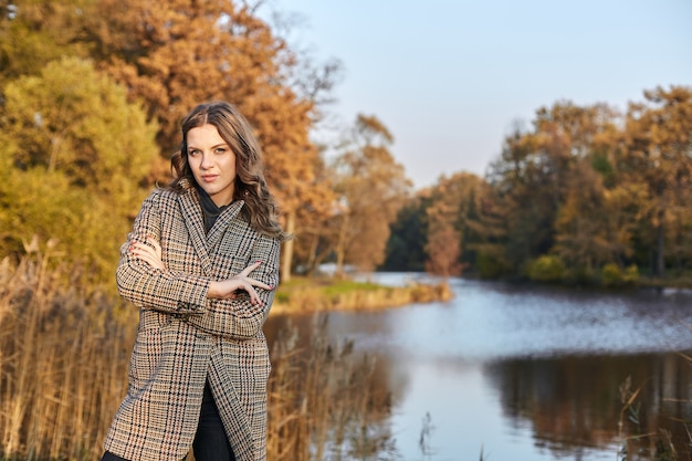 Woman wearing a coat and standing in park