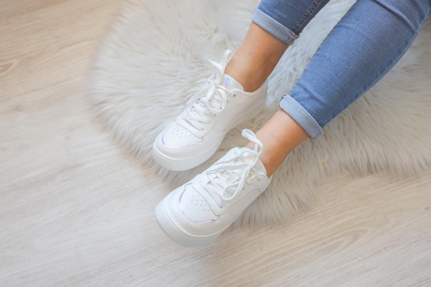 Woman wearing comfortable stylish sneakers indoors closeup