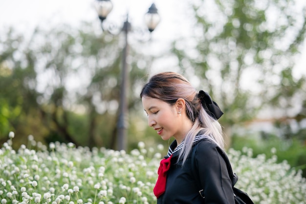 Woman wearing cosplay Japanese school uniform at park outdoor