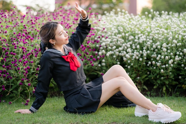 Woman wearing cosplay Japanese school uniform at park outdoor