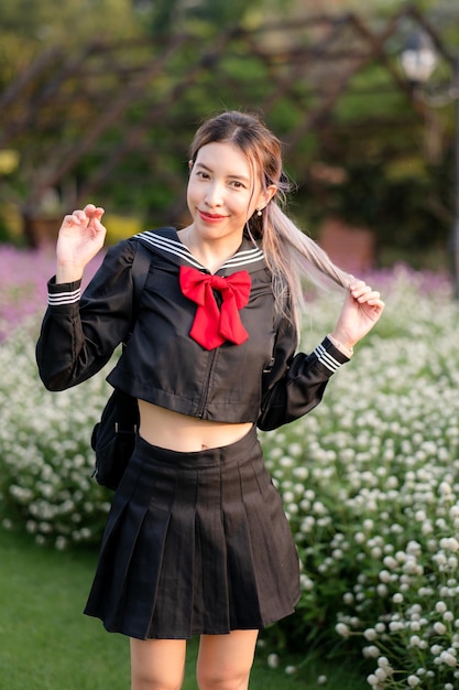 Woman wearing cosplay Japanese school uniform at park outdoor