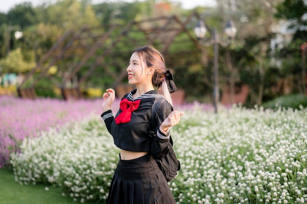 Woman wearing cosplay Japanese school uniform at park outdoor