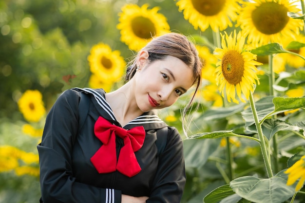 Woman wearing cosplay Japanese school uniform at sunflower garden outdoor